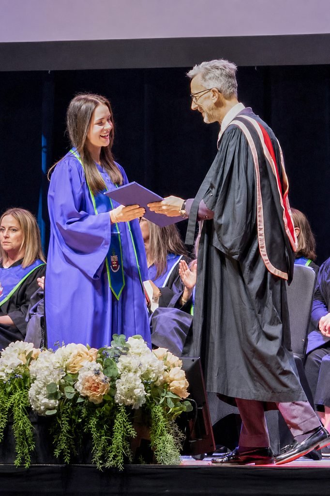 Graduate receiving a diploma on stage at Georgian College convocation