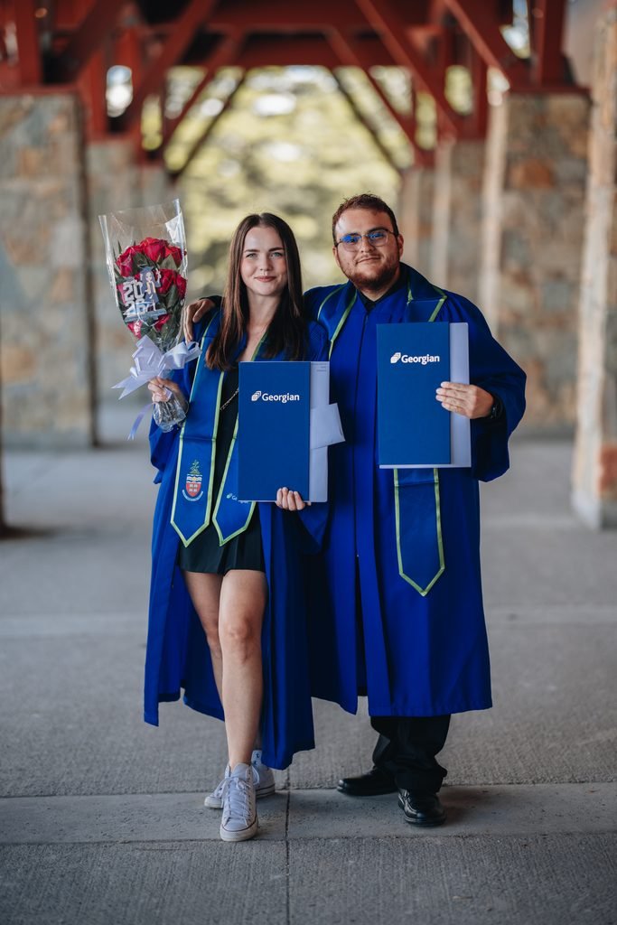 Two Georgian College graduates posing with their diplomas